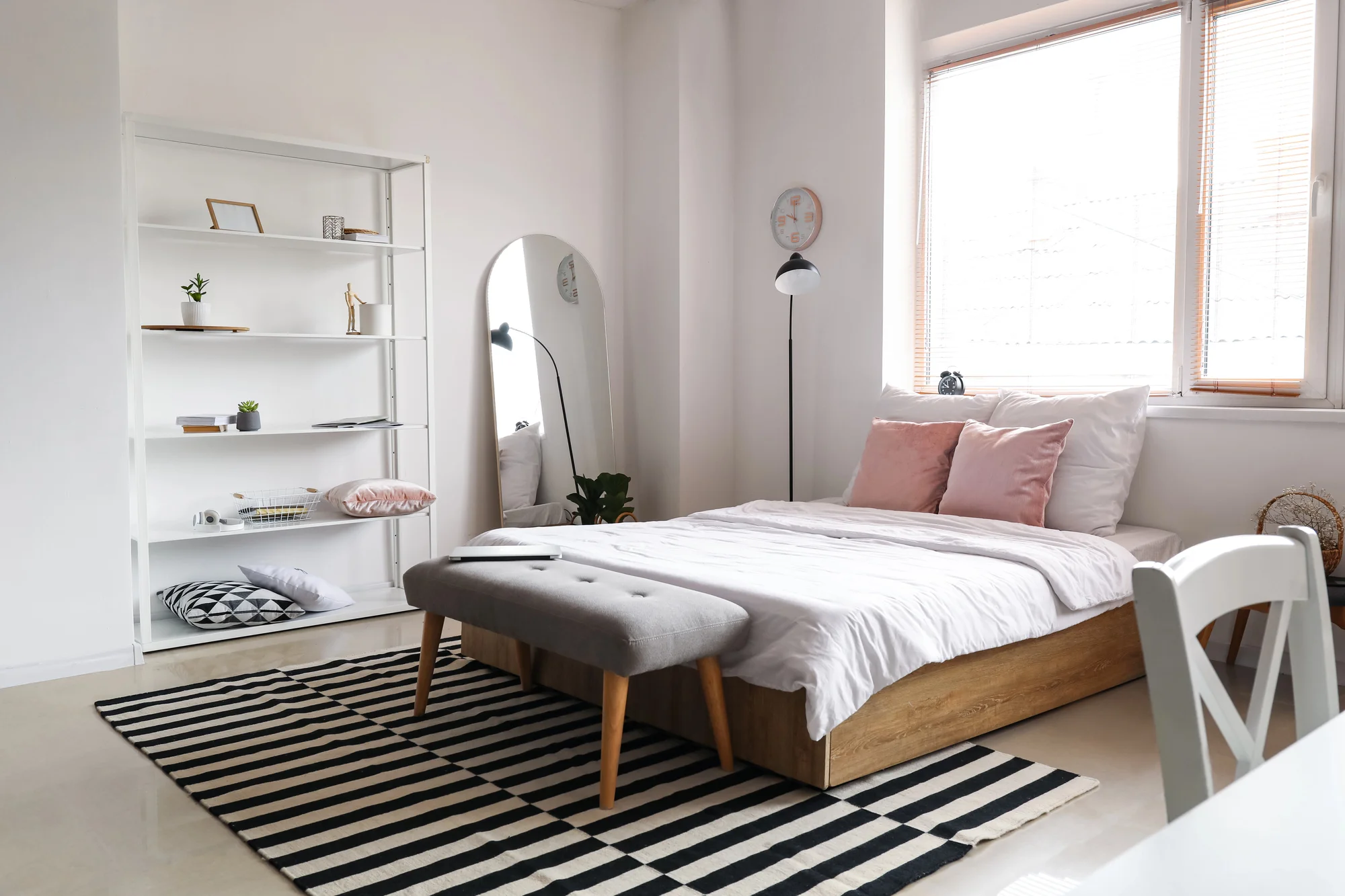 Nyrenoverat ljust sovrum med spegel och modern inredning